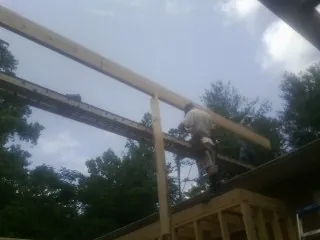 Carpenter setting a ridge beam over a new addition frame — Ice Dam Removal by Roofing Brothers in Adamstown