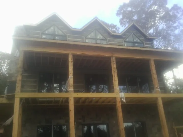 Dormers and porch framing on a large log home under construction — Roof Coating work by our crew in Adamstown